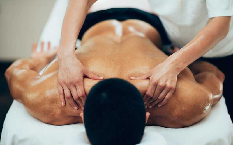 Sports massage. Therapist working with shoulders